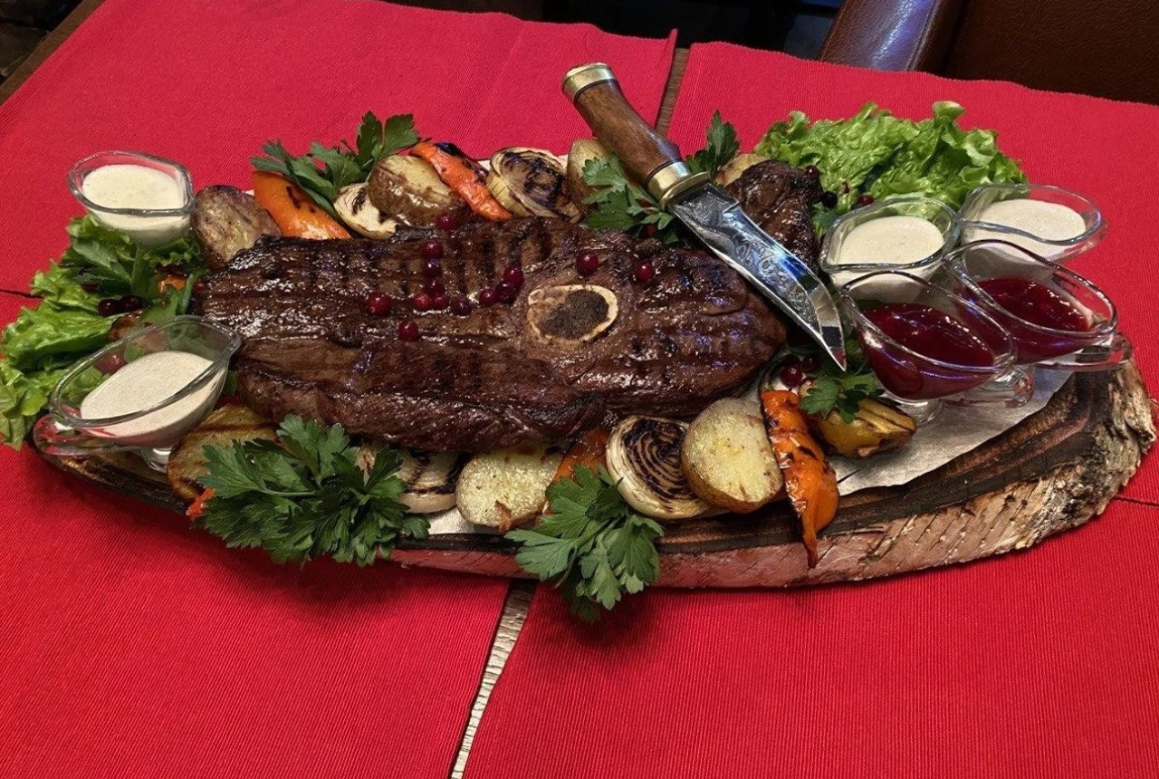 Большое мясное блюдо с зеленью и соусами